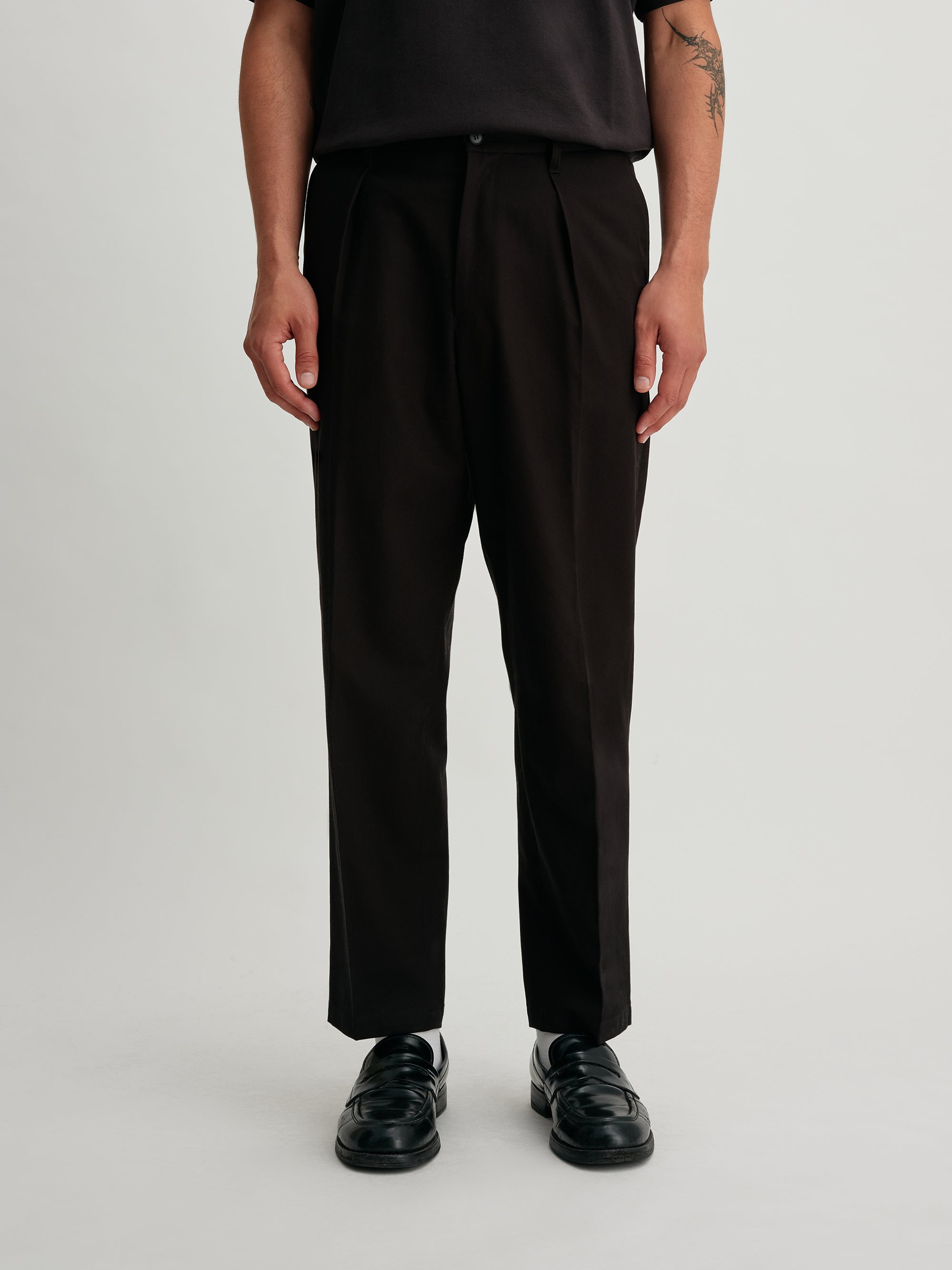 Saturdays NYC. 1Tuck Tapered Pants. Bottom view of the black chinos, showcasing the tapered hem and clean, structured finish.