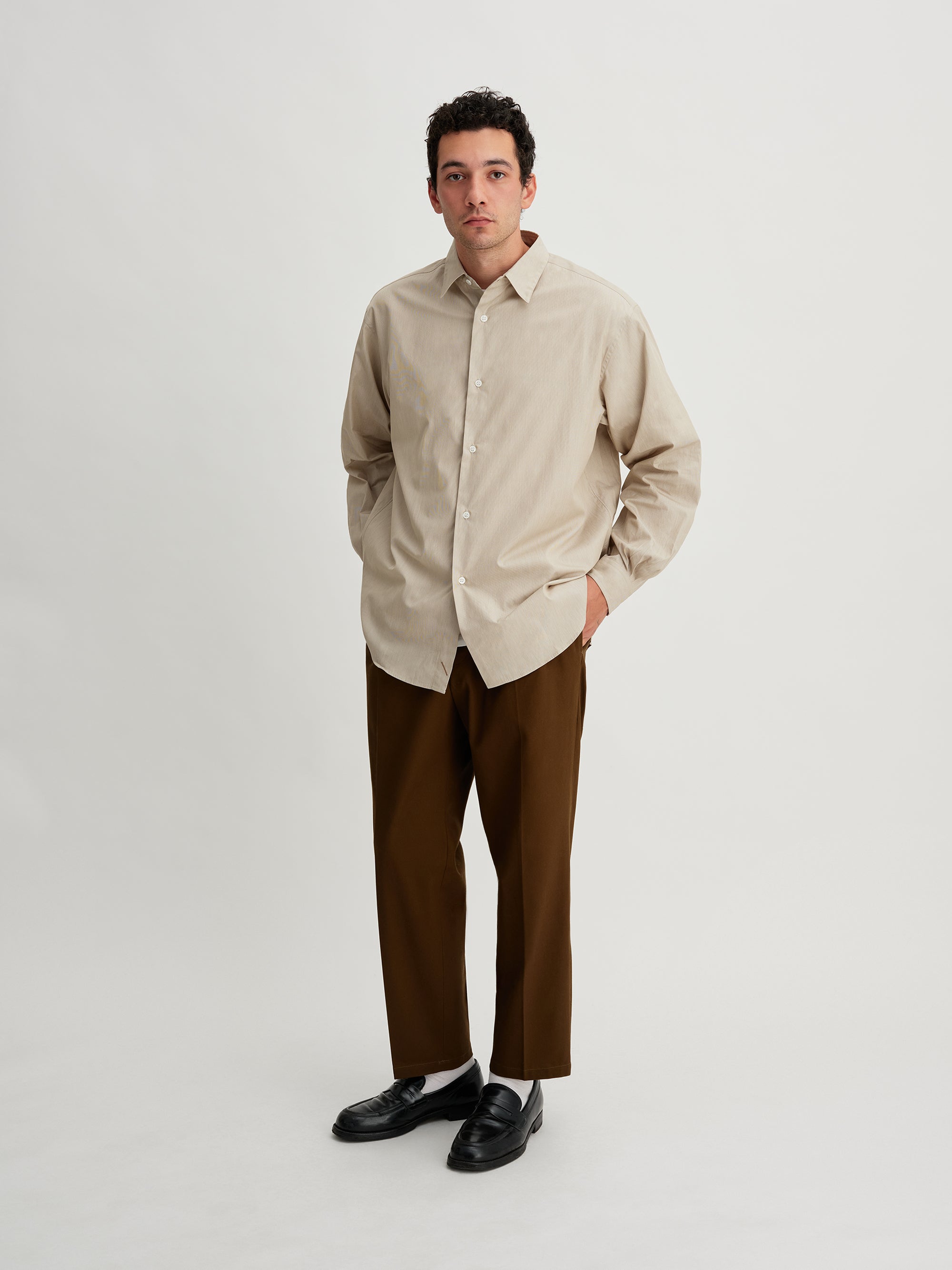 Saturdays NYC. 1Tuck Tapered Pants. Full-body view of model wearing the khaki chinos, showcasing the tapered fit and single tuck at the waist.